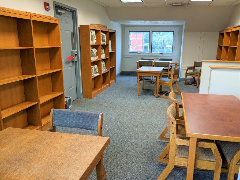 Room with tables, chairs and shelves.